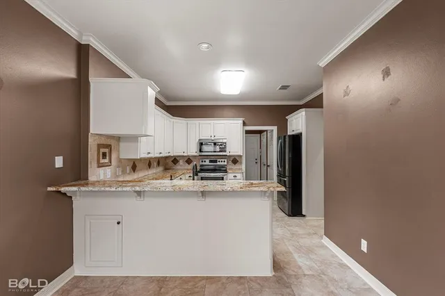 a kitchen with stainless steel appliances granite countertop a sink a stove and a refrigerator