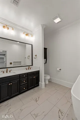 a spacious bathroom with a double vanity sink a toilet and a mirror