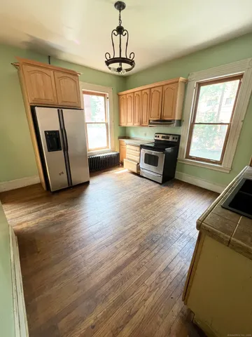 a view of an empty room with a window and wooden floor