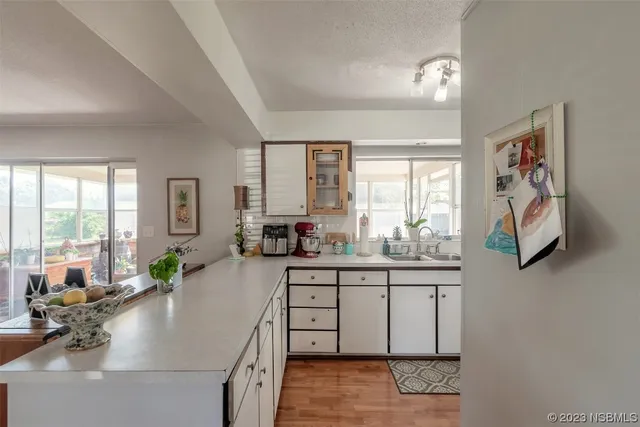 a kitchen with stainless steel appliances granite countertop a sink a stove cabinets wooden floor and a window