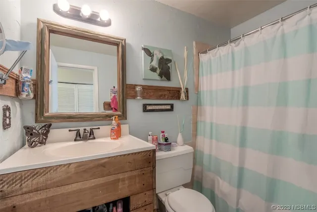 a bathroom with a sink toilet a shower curtain and a mirror