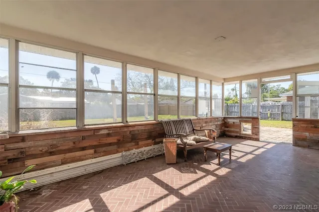 a living room with furniture and large windows