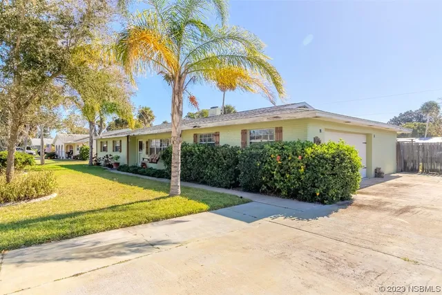 a view of a swimming pool with a yard and palm trees