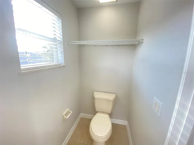 a white toilet sitting next to a window
