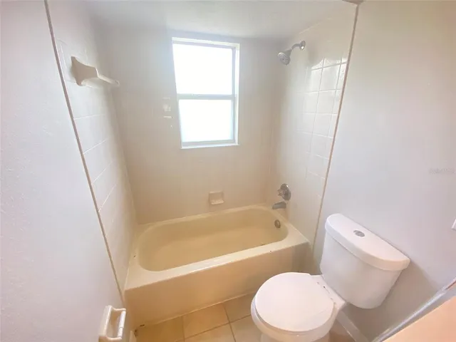 a white toilet sitting next to a bath tub