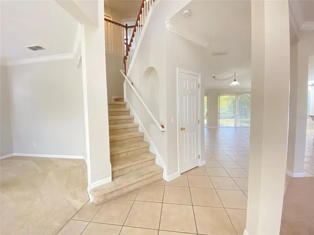 a view of a hallway with wooden floor and staircase