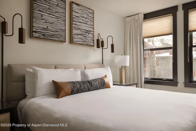 a bedroom with a bed next to a window