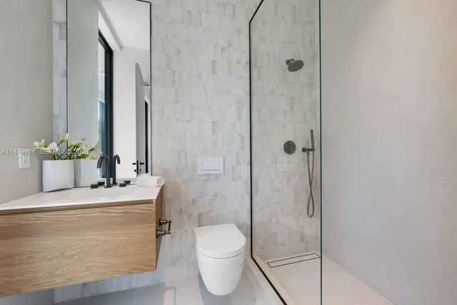 a bathroom with a granite countertop sink a toilet and shower