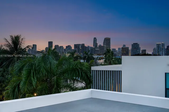 a balcony with couple of chairs and a potted plant