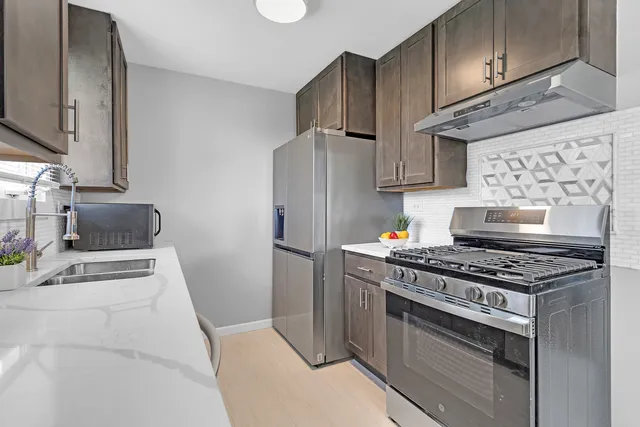 a kitchen with stainless steel appliances granite countertop a stove a refrigerator and a sink