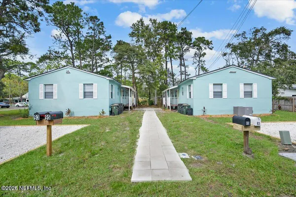 a front view of a house with a yard and trees