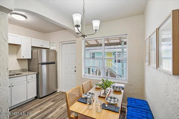 a kitchen with a refrigerator a stove and a wooden floor