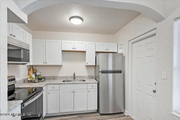 a kitchen with a refrigerator sink and cabinets