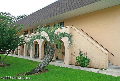a front view of yellow house with garden