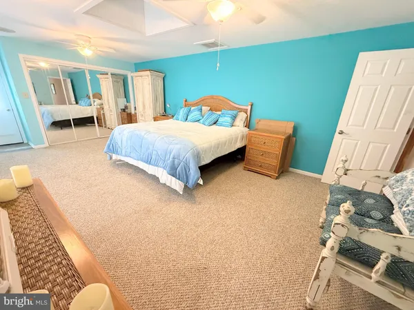 a spacious bedroom with a bed and a chandelier