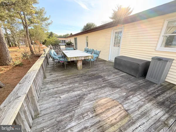 a balcony with couple of white couch and chairs