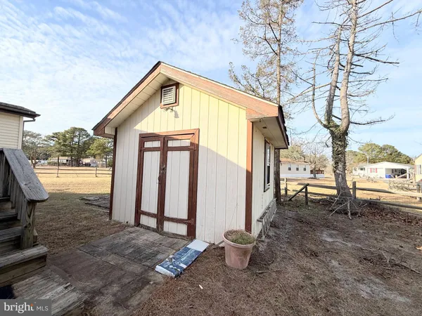 a view of a house with a yard and large trees