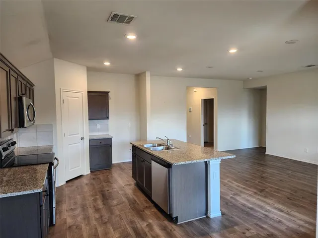 a kitchen with stainless steel appliances granite countertop a sink stove and refrigerator