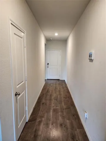 a view of a hallway with wooden floor