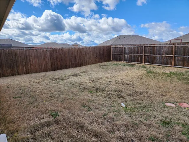 a view of backyard with wooden fence