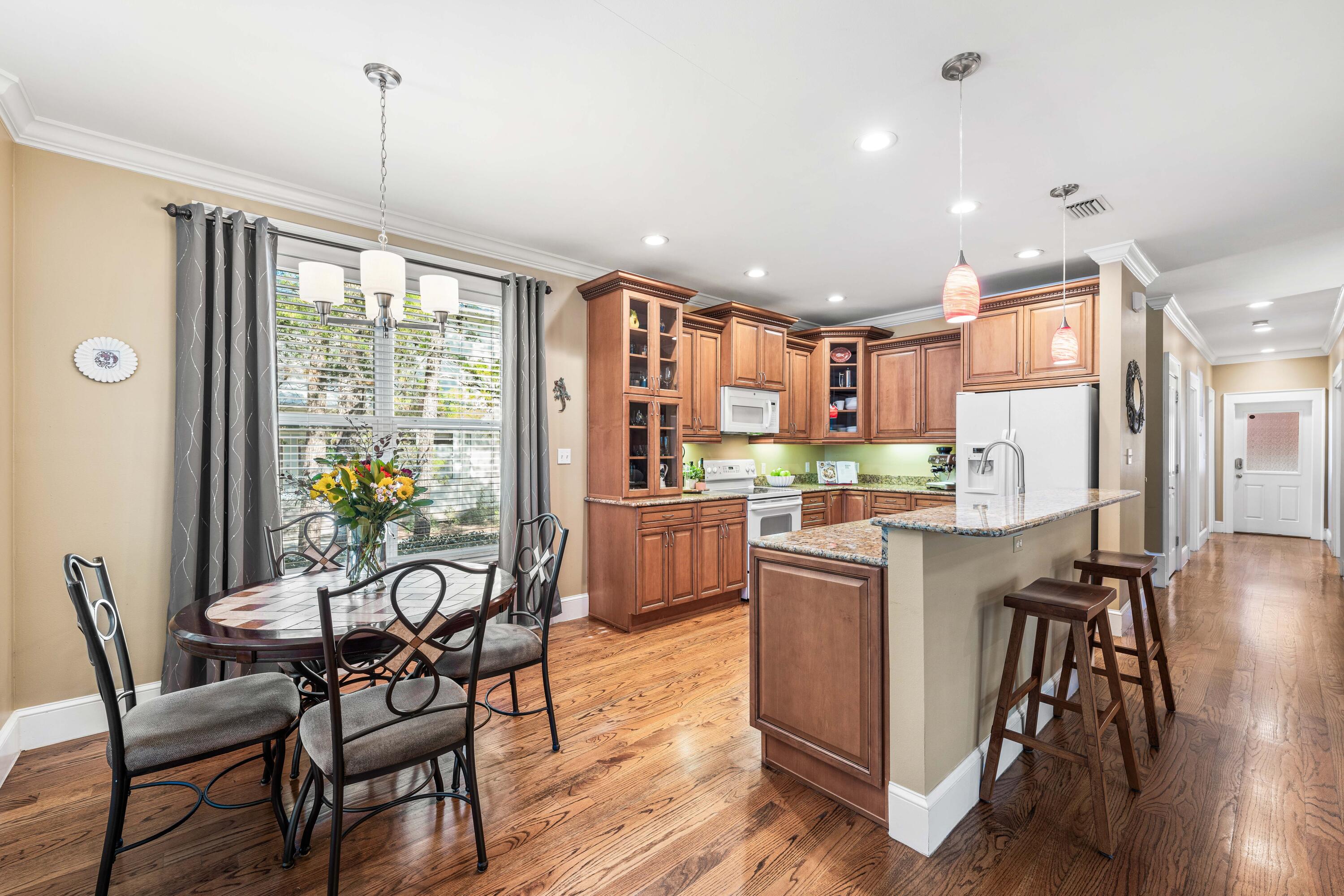 556 Little Canal Drive Santa Rosa Beach, FL 32459 - Photo 21 of 60 a kitchen with a table chairs refrigerator and microwave