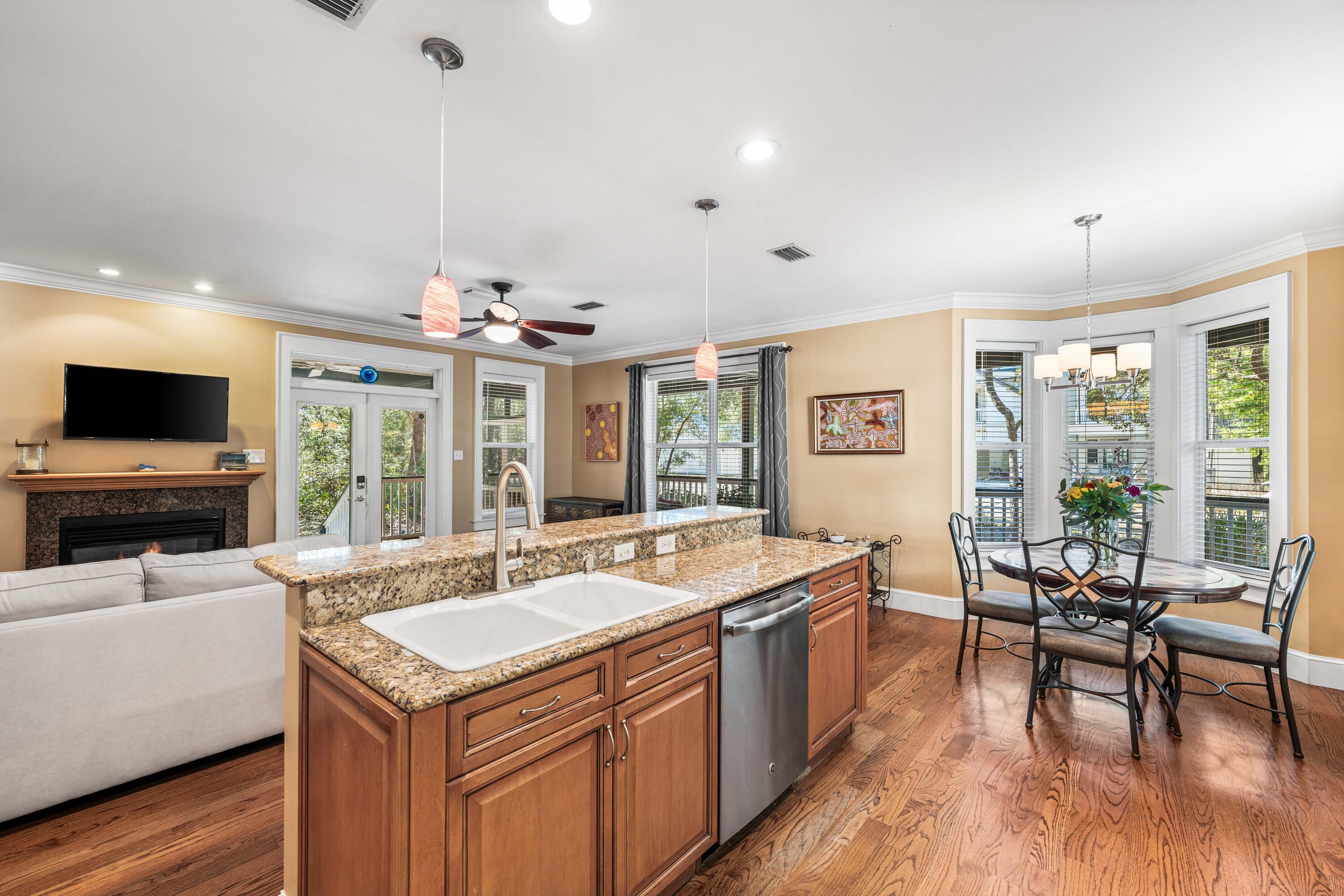 556 Little Canal Drive Santa Rosa Beach, FL 32459 - Photo 26 of 60 a view of a kitchen with kitchen island a sink and a stove top oven with wooden floor