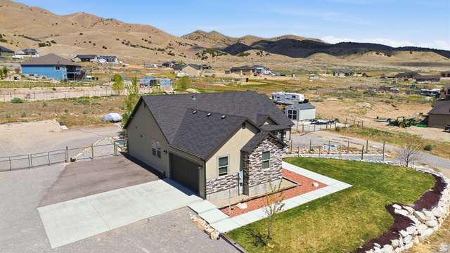 1588 West Rim Rock Drive Stockton, UT 84071 - Photo 57 of 61 Single-story residence featuring a two-car garage, stone and stucco exterior, and a dark shingle roof