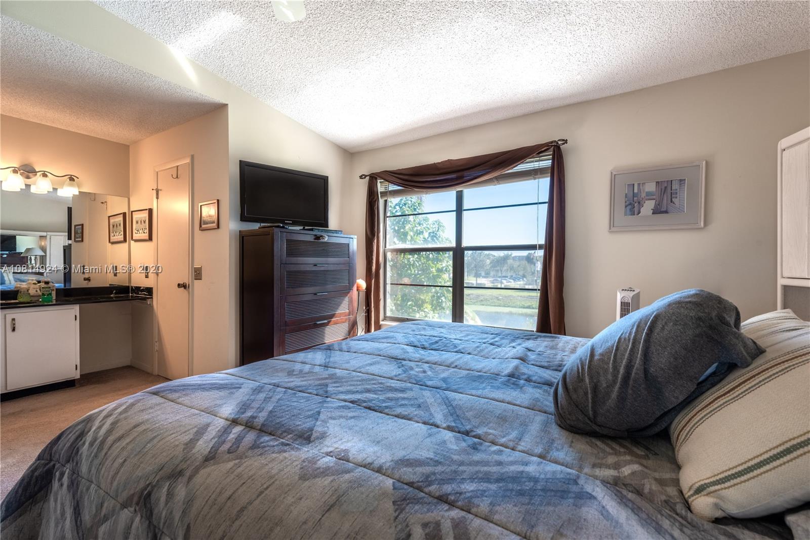 8814 Southwest 22nd Street, Unit B Boca Raton, FL 33433 - Photo 15 of 38 a bedroom with a bed and a large window