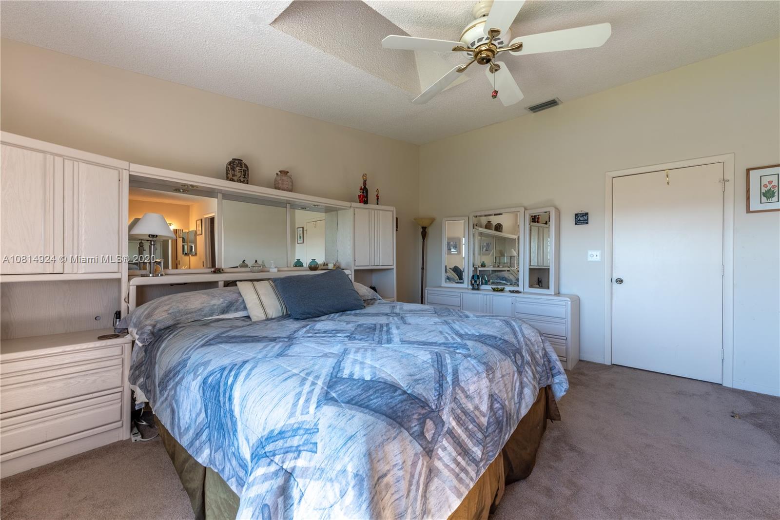 8814 Southwest 22nd Street, Unit B Boca Raton, FL 33433 - Photo 19 of 38 a bedroom with a large bed and ceiling fan