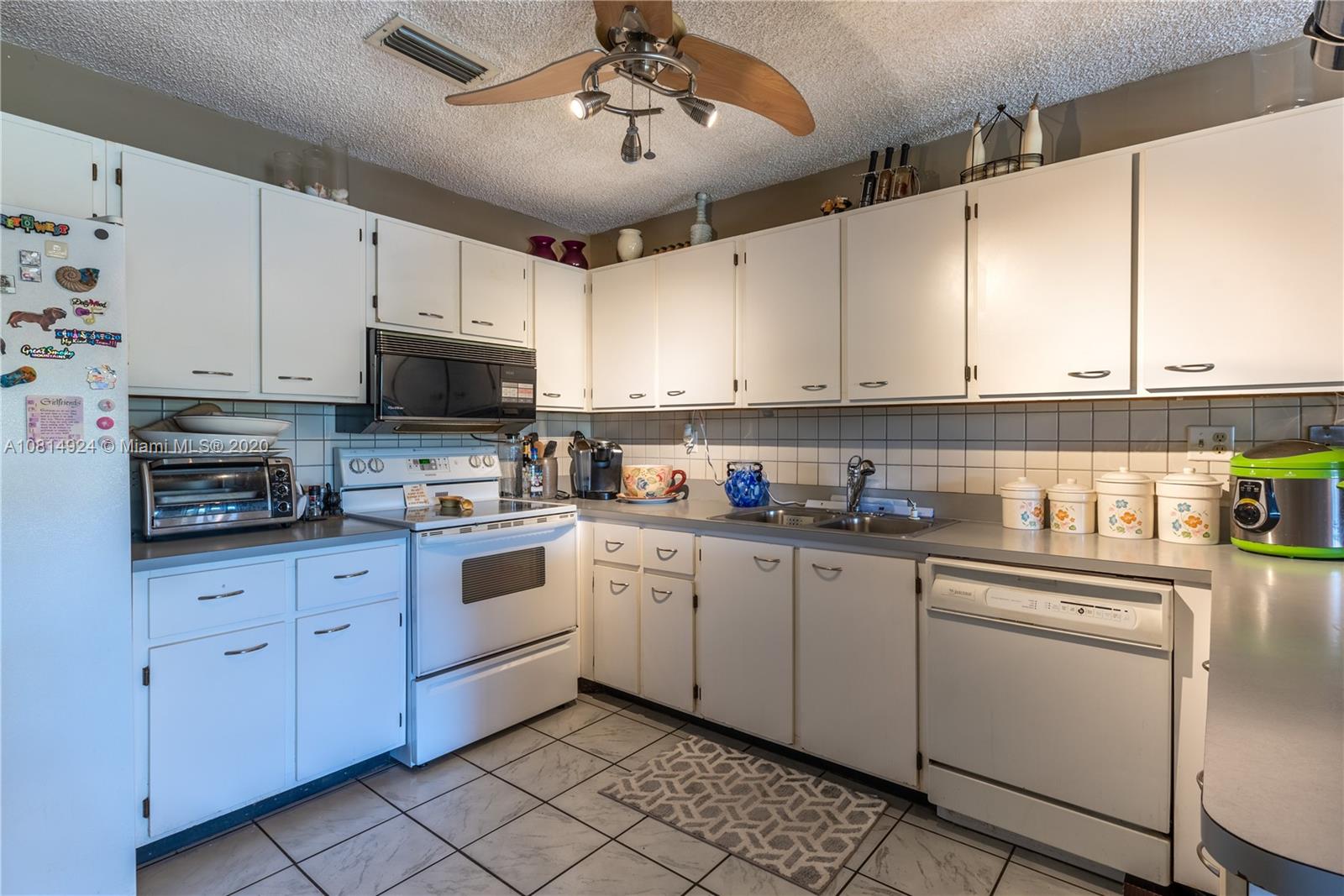 8814 Southwest 22nd Street, Unit B Boca Raton, FL 33433 - Photo 4 of 38 a kitchen with cabinets appliances a sink and a counter top space