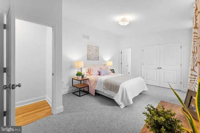 a bedroom with a bed and a refrigerator