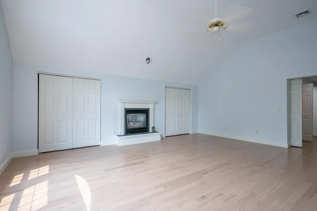 a view of an empty room with a fireplace and a window
