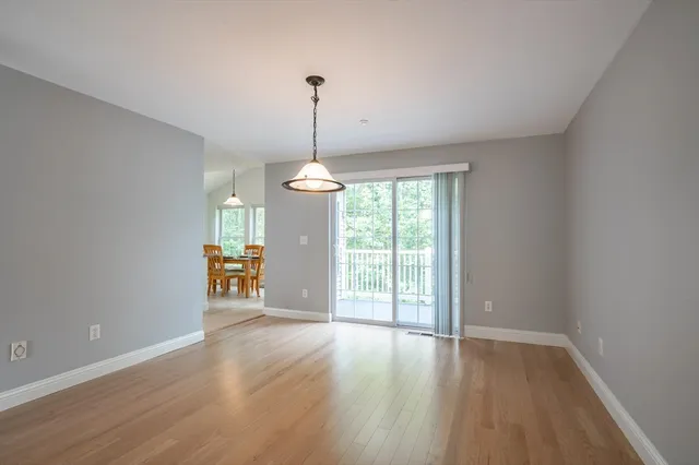 a view of empty room with wooden floor and outdoor view