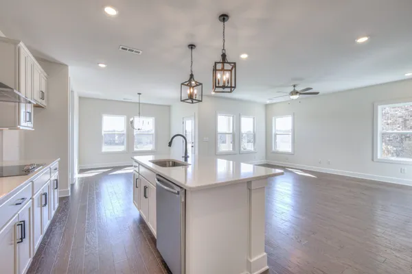 a kitchen with stainless steel appliances granite countertop a sink stove and wooden floor