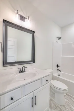 a bathroom with a sink a toilet and a mirror