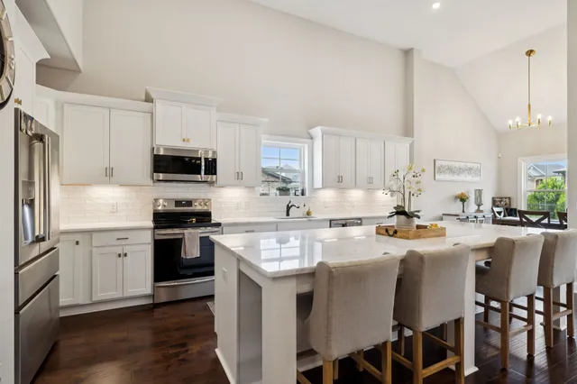 a kitchen with stainless steel appliances granite countertop a stove refrigerator sink and cabinets
