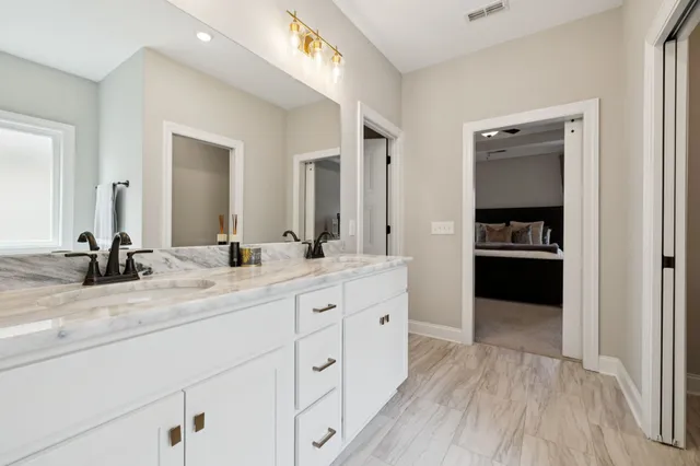 a en suite bathroom with a double vanity sink and a mirror