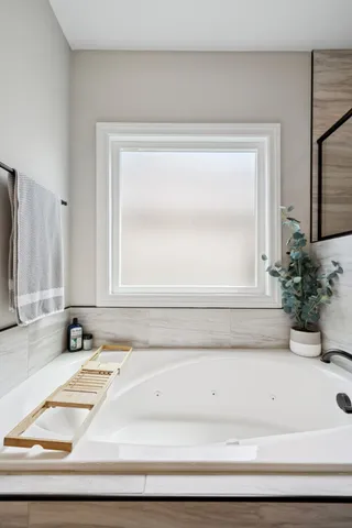 a bathroom with a bathtub and a window