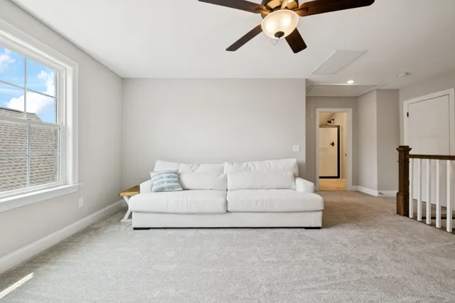 a living room with furniture and a chandelier fan