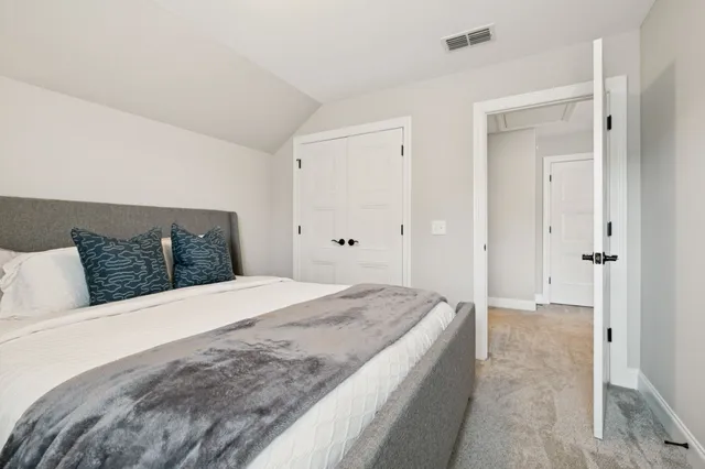 a spacious bedroom with a large bed and walk in closet