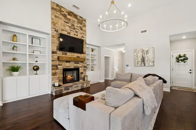 a living room with furniture a flat screen tv and a fireplace