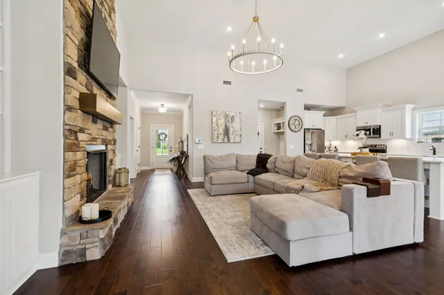 a living room with furniture kitchen view and a chandelier