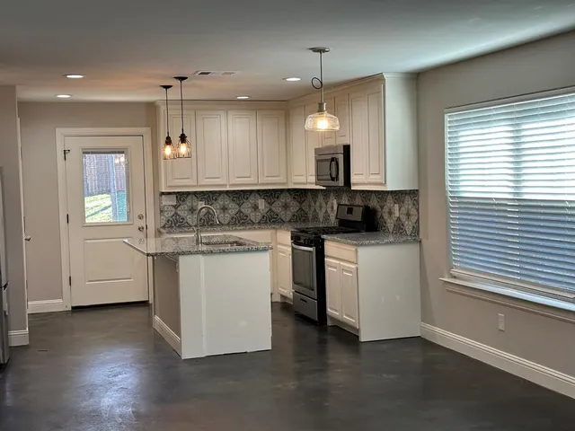 a kitchen with a white cabinets and sink
