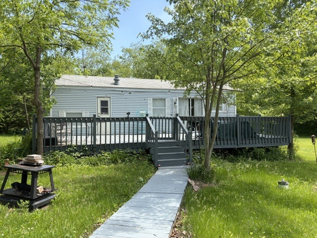 a view of a house with a yard deck and a small yard