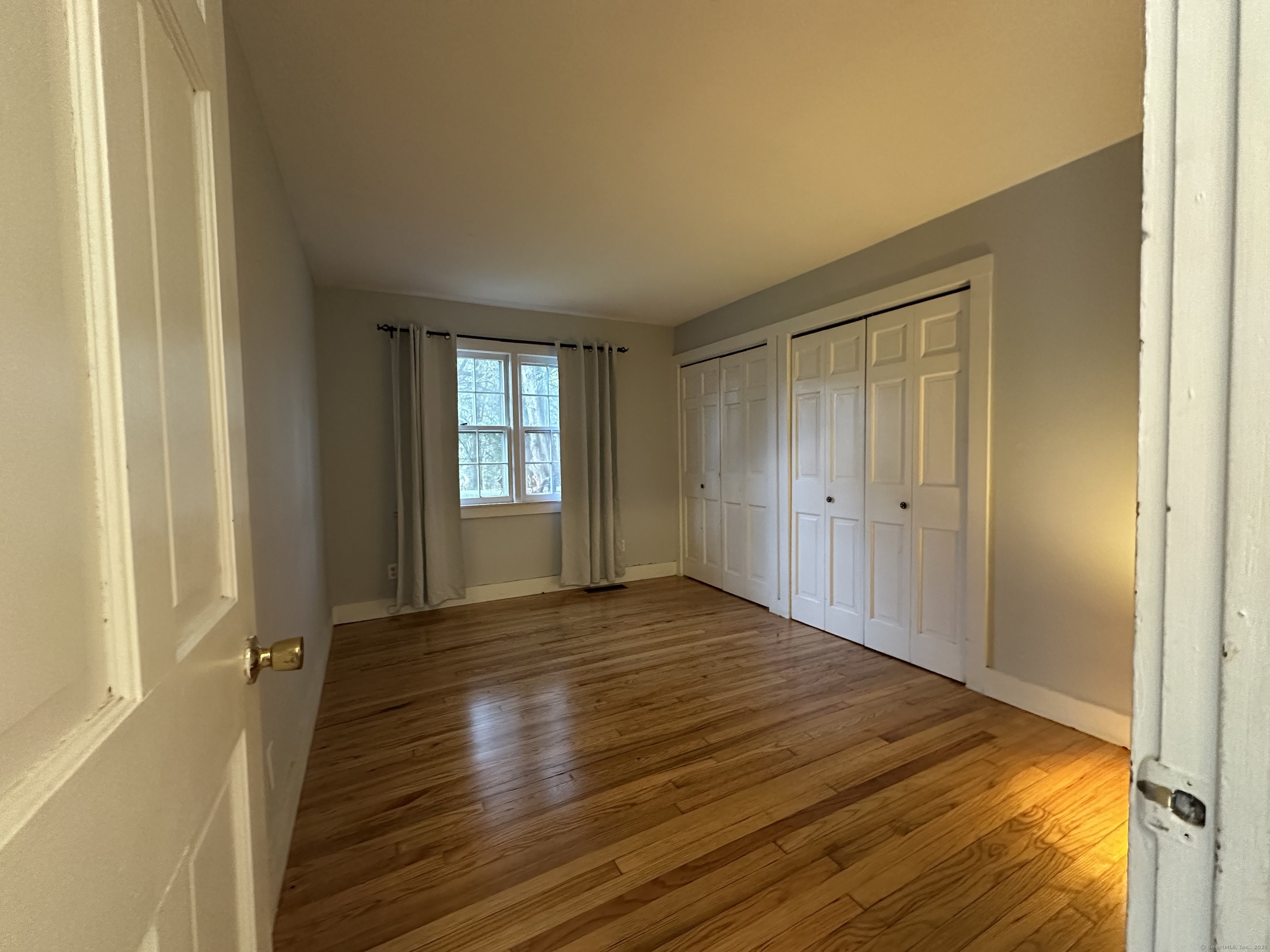 25 Elephant Rock Road, Unit 2 Woodbury, CT 06798 - Photo 11 of 17 a view of an empty room with wooden floor and a window