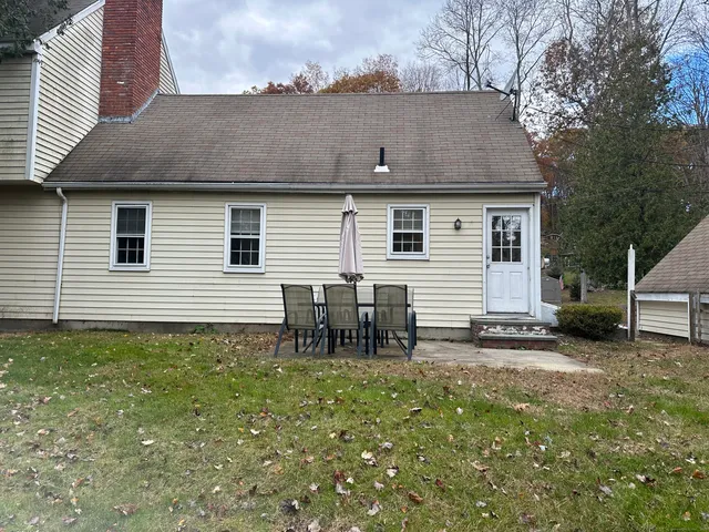 a backyard of a house with table and chairs