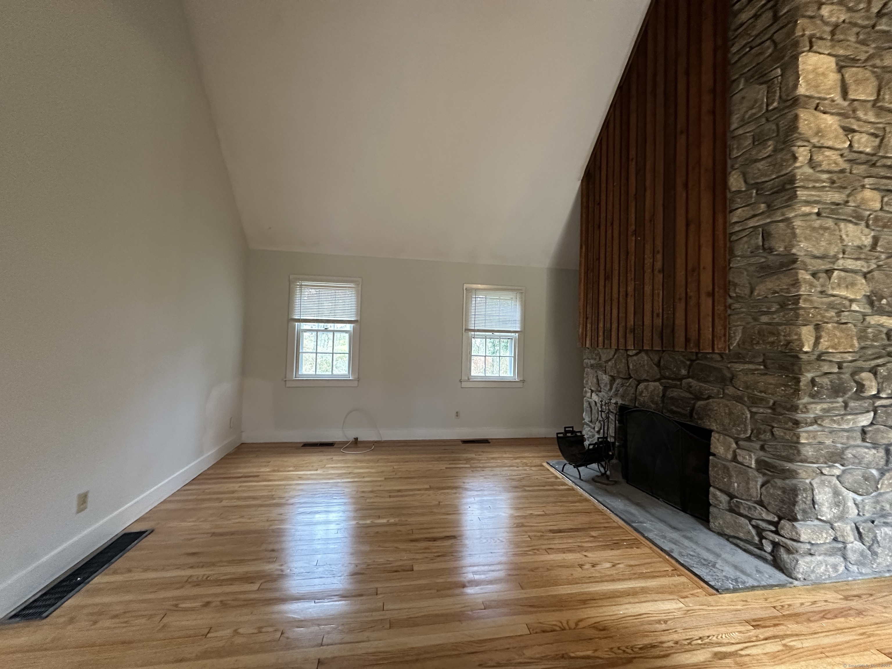 25 Elephant Rock Road, Unit 2 Woodbury, CT 06798 - Photo 3 of 17 a view of empty room with wooden floor and fireplace