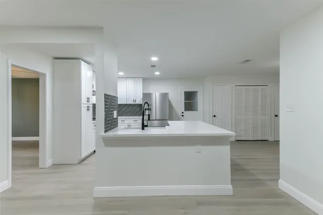 a kitchen with stainless steel appliances a refrigerator sink and microwave
