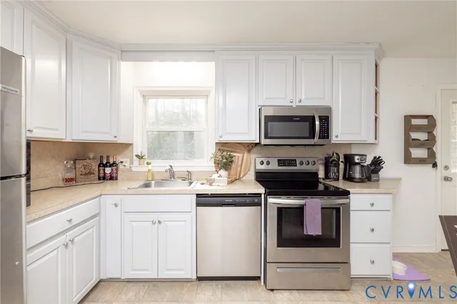 a kitchen with granite countertop white cabinets and stainless steel appliances