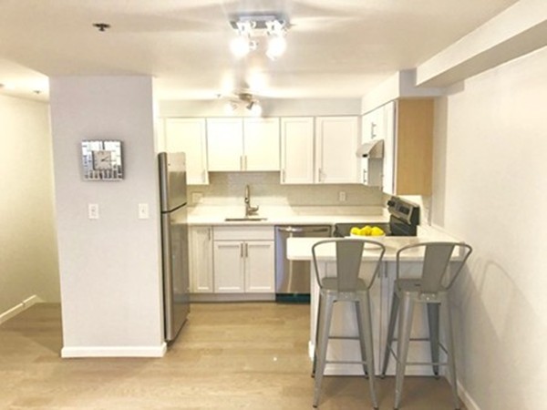 a kitchen with a table chairs refrigerator and cabinets